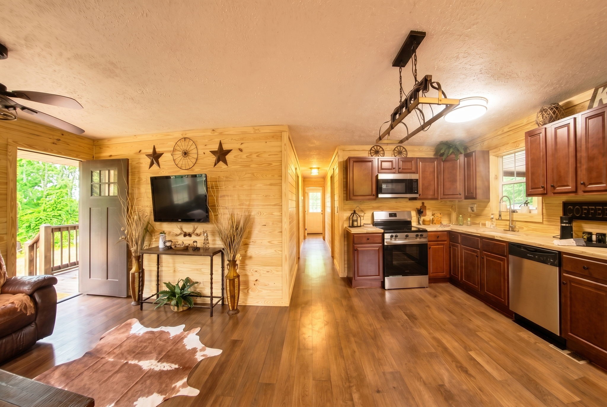 292 Harmony Road Gainesboro, TN 38562 - Photo 24 of 61 a large open kitchen with kitchen island granite countertop a stove top oven a sink a dining table and chairs with wooden floor
