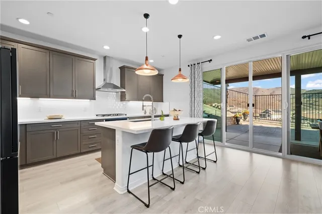 a kitchen with a table chairs stove and wooden floor