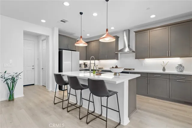 a kitchen with a dining table chairs sink and wooden cabinets