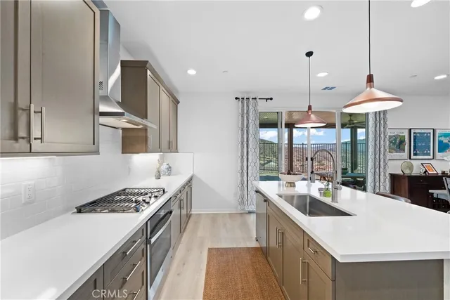 a kitchen with a stove a refrigerator a sink and dishwasher with wooden floor