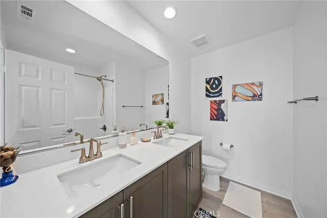 a bathroom with a sink mirror vanity and toilet