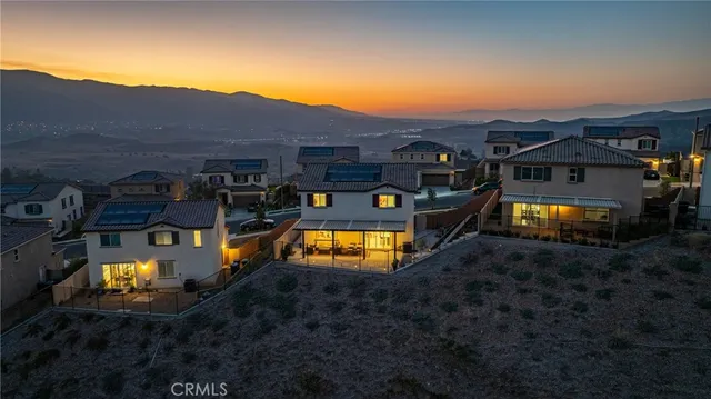 an aerial view of a house with a swimming pool a yard and a mountain view