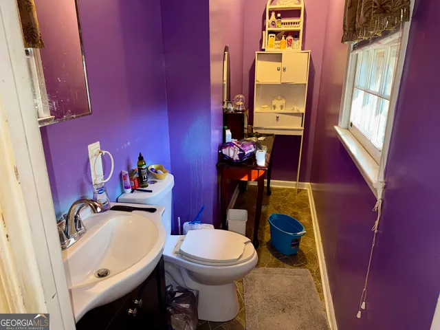 a bathroom with a toilet a sink and a mirror