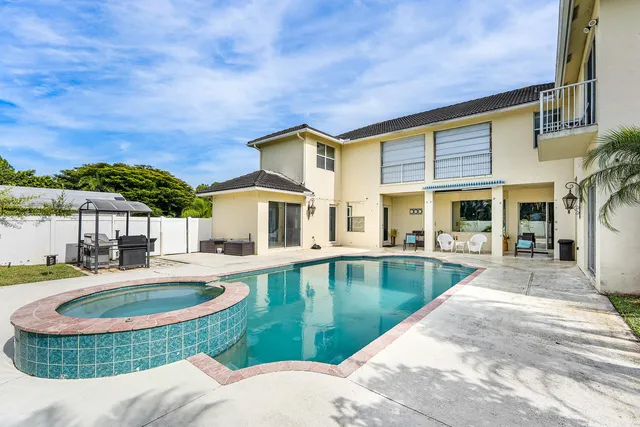 a view of a house with swimming pool and sitting area