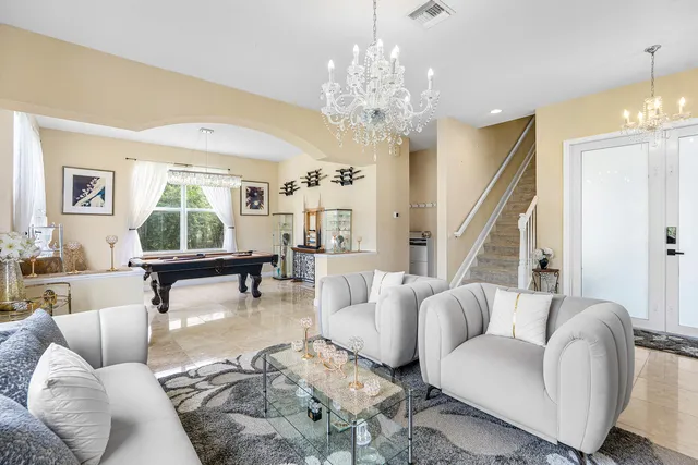 a living room with furniture and a chandelier