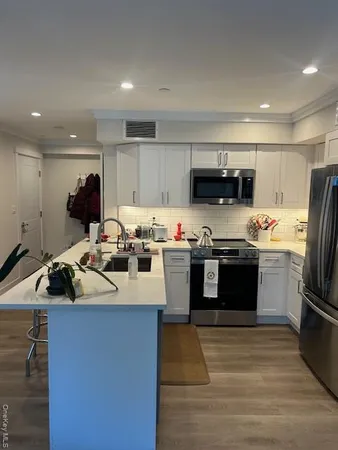 a kitchen with kitchen island a sink appliances and cabinets