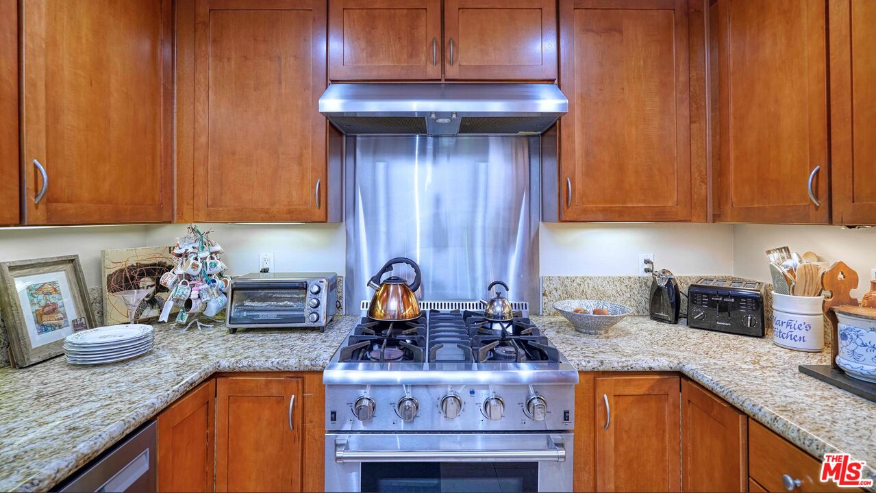 2240 South Beverly Glen Boulevard, Unit 103 Los Angeles, CA 90064 - Photo 12 of 27 a kitchen with granite countertop wood cabinets and a sink