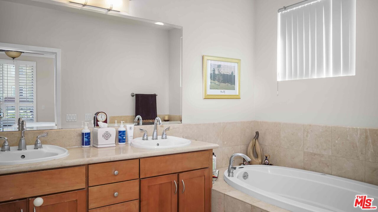 2240 South Beverly Glen Boulevard, Unit 103 Los Angeles, CA 90064 - Photo 21 of 27 a bathroom with a tub sink double vanity and mirror
