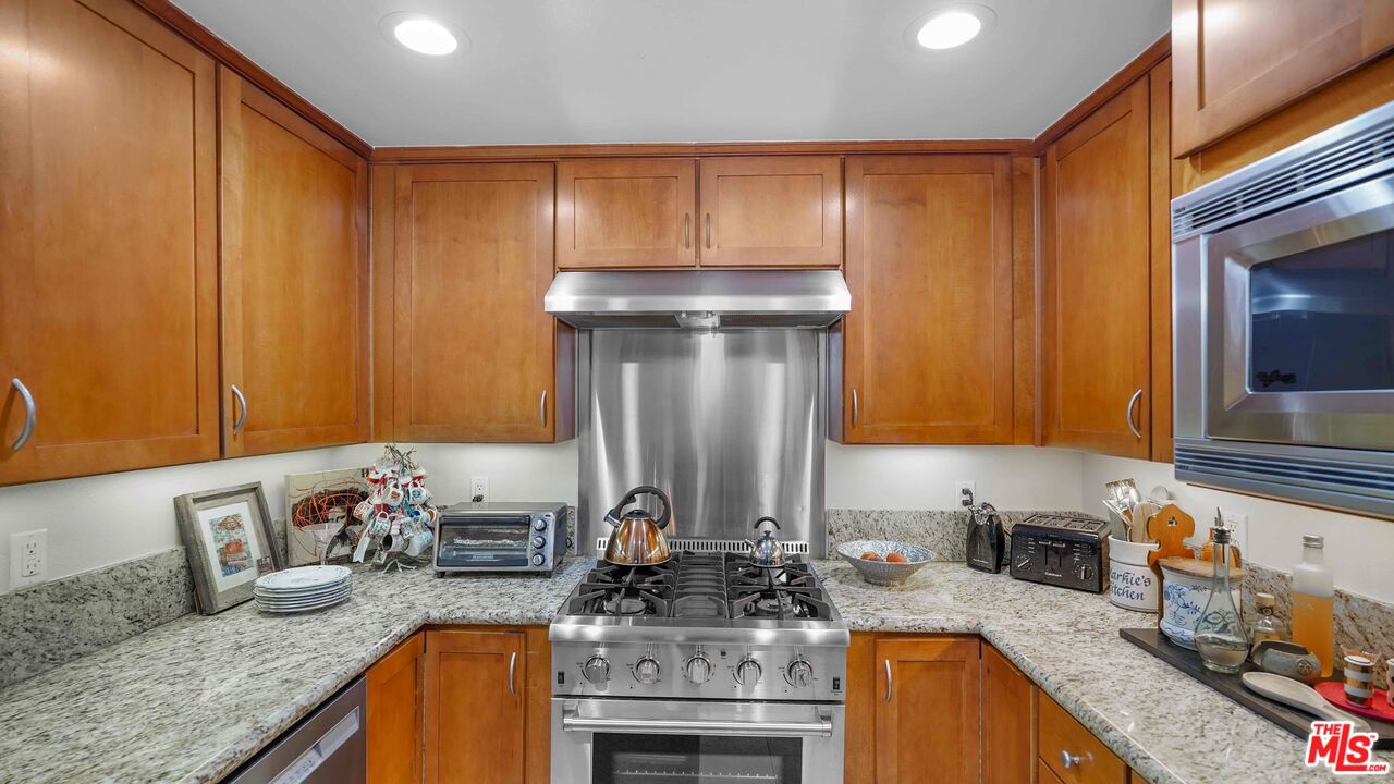 2240 South Beverly Glen Boulevard, Unit 103 Los Angeles, CA 90064 - Photo 10 of 27 a kitchen with granite countertop a sink stove and cabinets