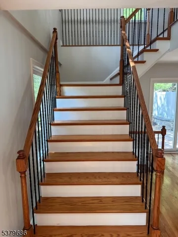 a view of a hallway with wooden floor and staircase