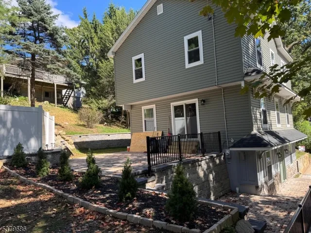 a front view of house yard with table and chairs and potted plants