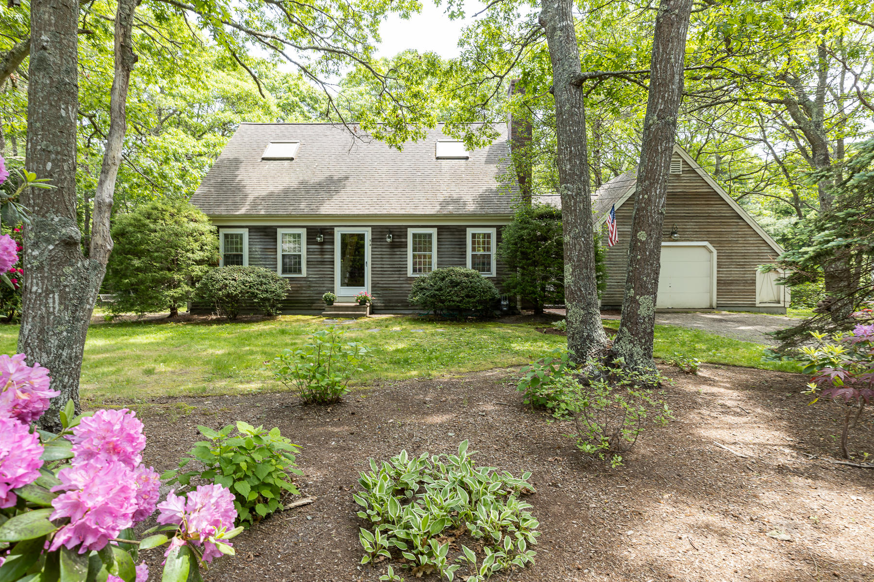 54 Crawford Road Cotuit, MA 02635 - Photo 1 of 46 a front view of a house with garden
