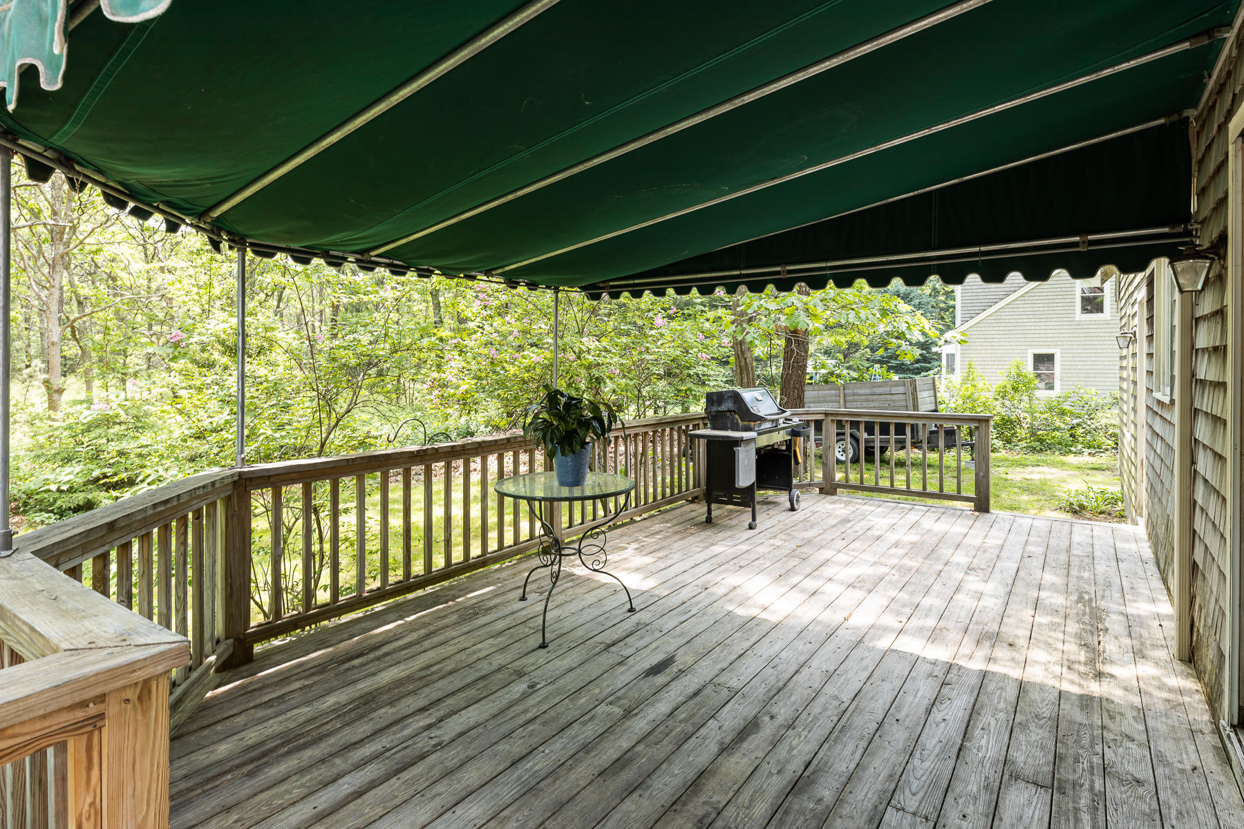 54 Crawford Road Cotuit, MA 02635 - Photo 32 of 46 a porch with wooden floor in front of a yard