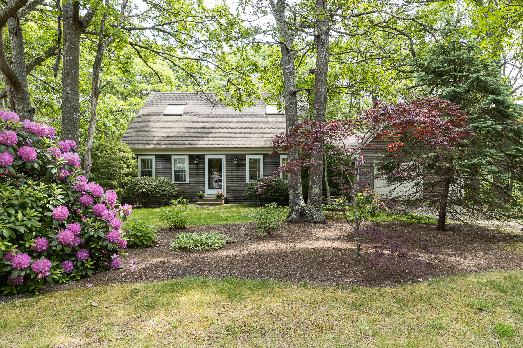 54 Crawford Road Cotuit, MA 02635 - Photo 36 of 46 a front view of a house with a yard and fountain