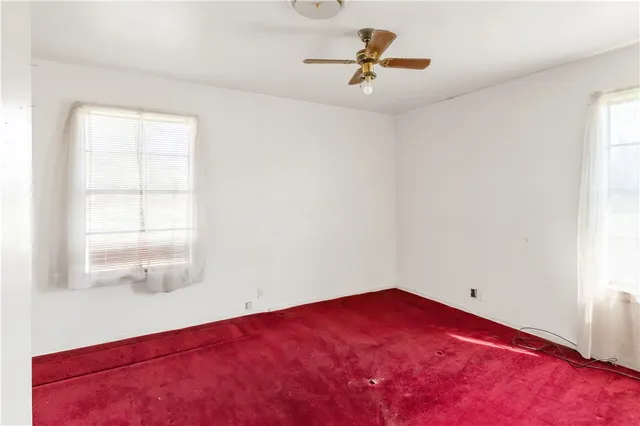 a view of a room with a ceiling fan and window