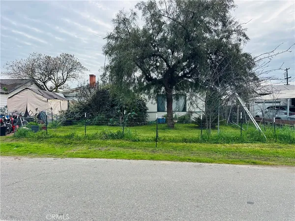 a view of a house with a big yard and large trees