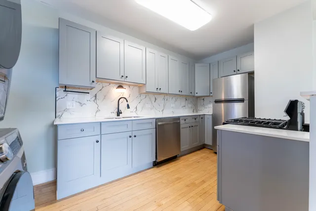 a kitchen with stainless steel appliances granite countertop a sink stove and refrigerator