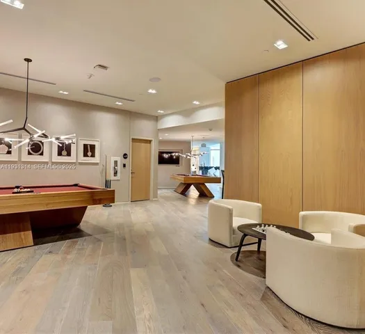 a living room with couches a large dining table and chairs with wooden floor