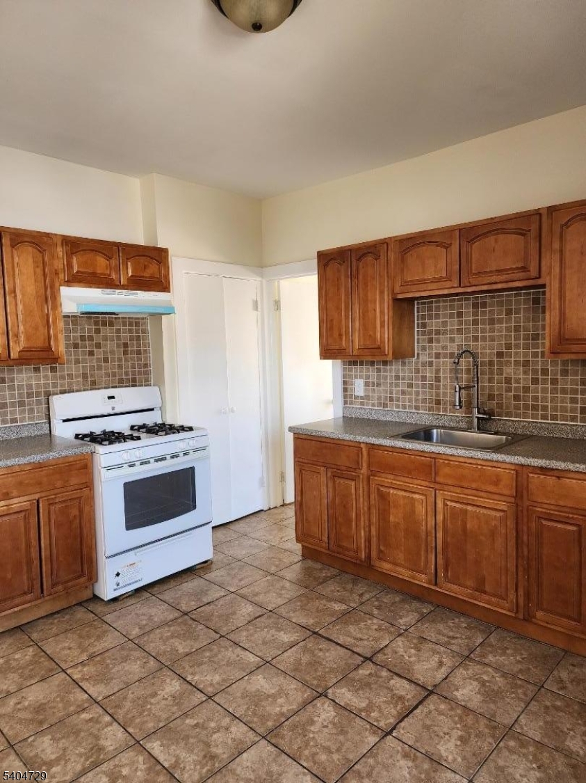 239 Magnolia Avenue Elizabeth Port, NJ 07206 - Photo 2 of 11 a kitchen with stainless steel appliances granite countertop a stove a sink and a refrigerator