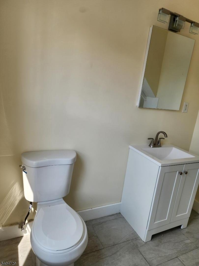 239 Magnolia Avenue Elizabeth Port, NJ 07206 - Photo 3 of 11 a white toilet sitting next to a bathroom sink