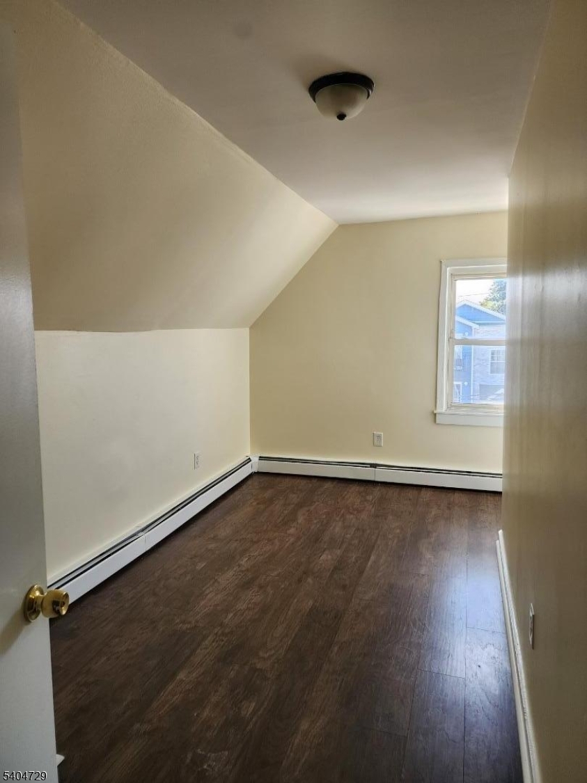 239 Magnolia Avenue Elizabeth Port, NJ 07206 - Photo 8 of 11 an empty room with wooden floor and windows