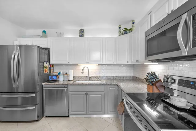 a kitchen with stainless steel appliances a stove a sink and cabinets