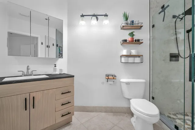 a bathroom with a granite countertop toilet sink and mirror