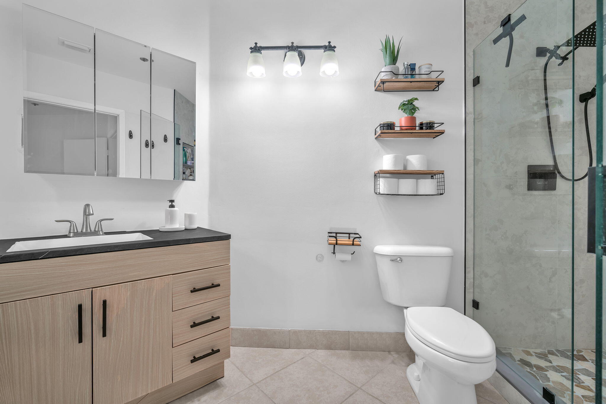 5157 Floria Way, Unit T Boynton Beach, FL 33437 - Photo 14 of 40 a bathroom with a granite countertop toilet sink and mirror