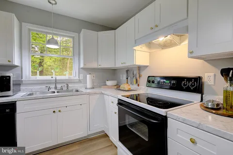 a bathroom with a granite countertop sink a toilet and shower