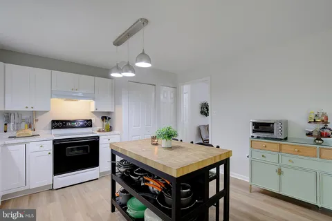 a kitchen with refrigerator and white cabinets