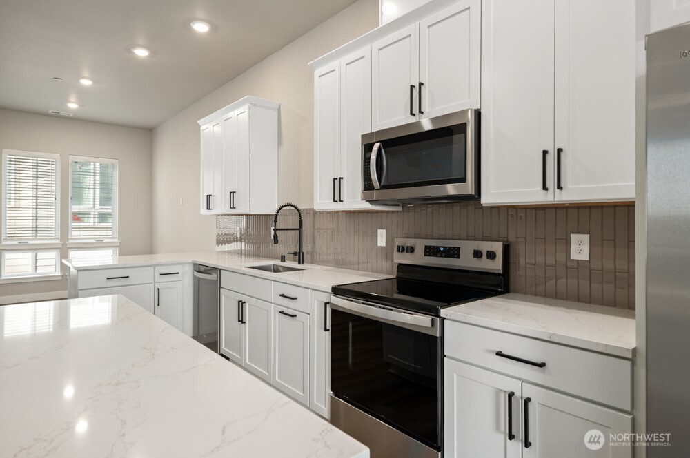 6619 South 128th Street Seattle, WA 98178 - Photo 9 of 20 a kitchen with a sink stove and microwave