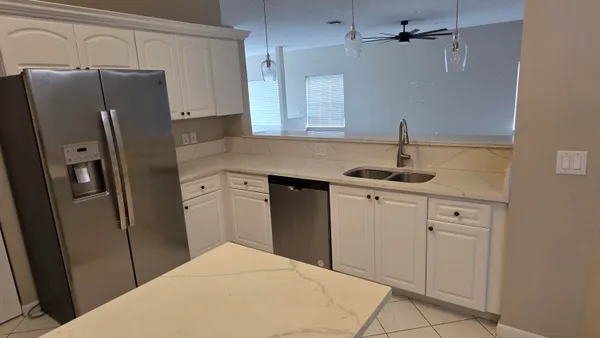 a kitchen with stainless steel appliances granite countertop a refrigerator and a sink