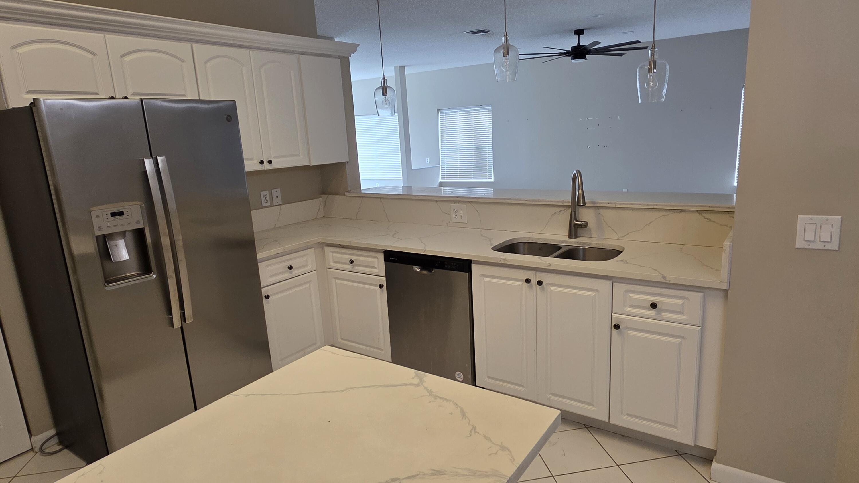 7769 Mansfield Hollow Road Delray Beach, FL 33446 - Photo 11 of 27 a kitchen with stainless steel appliances granite countertop a refrigerator and a sink