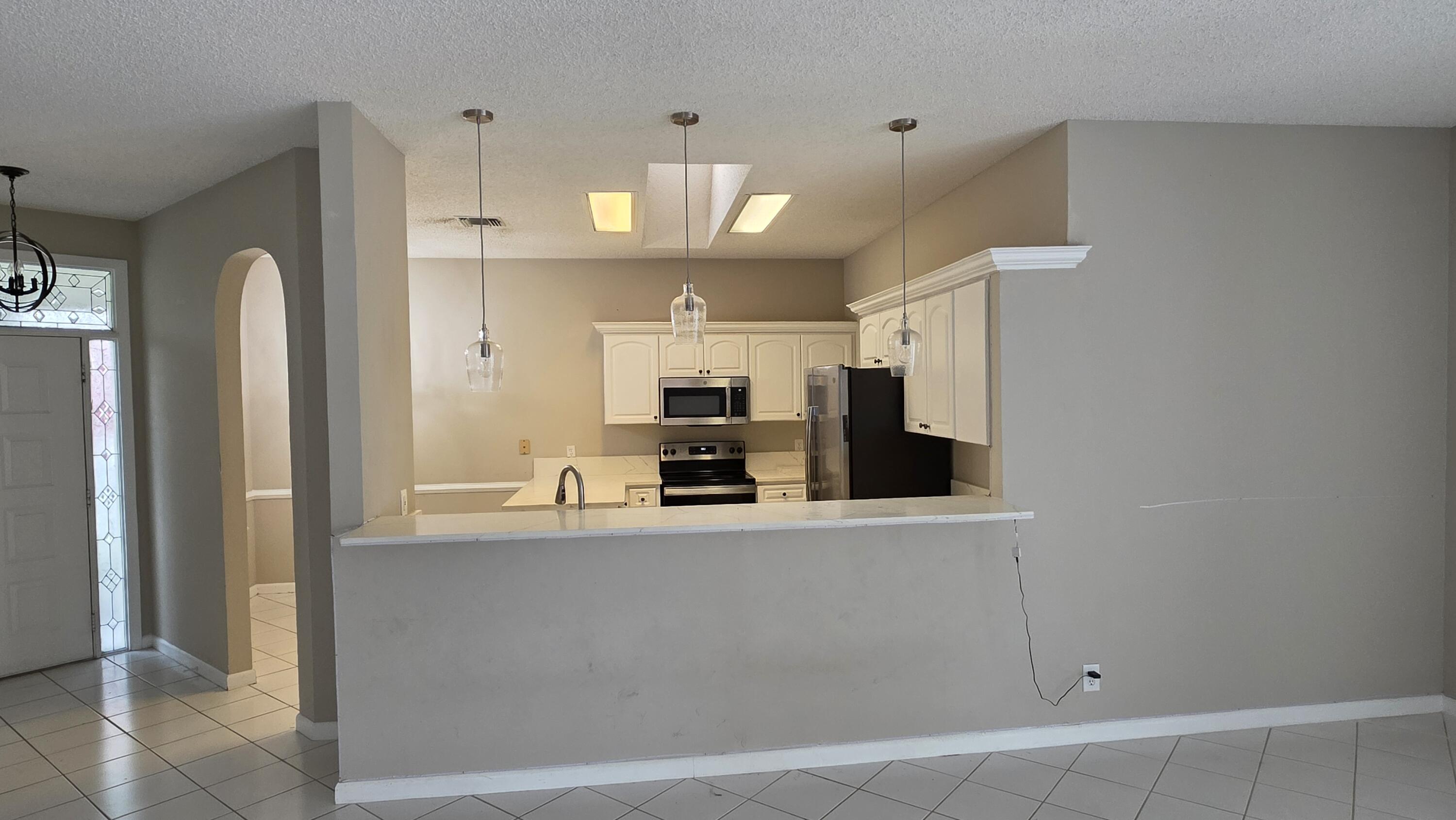 7769 Mansfield Hollow Road Delray Beach, FL 33446 - Photo 8 of 27 a large kitchen with a large counter top appliances and cabinets