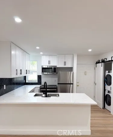 a kitchen with stainless steel appliances a refrigerator sink stove and cabinets