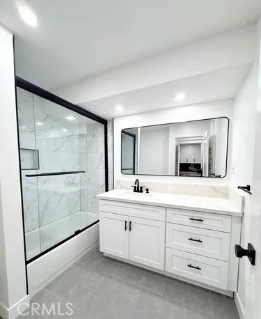 a bathroom with a double vanity sink mirror and bathtub