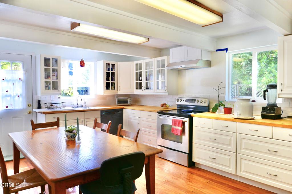 31421 State Highway 20 Fort Bragg, CA 95437 - Photo 8 of 28 a kitchen with stainless steel appliances granite countertop a stove a sink dishwasher and cabinets with wooden floor