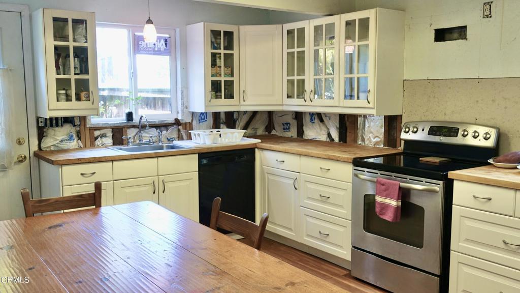 31421 State Highway 20 Fort Bragg, CA 95437 - Photo 10 of 28 a kitchen with stainless steel appliances granite countertop a stove a sink dishwasher and white cabinets with wooden floor