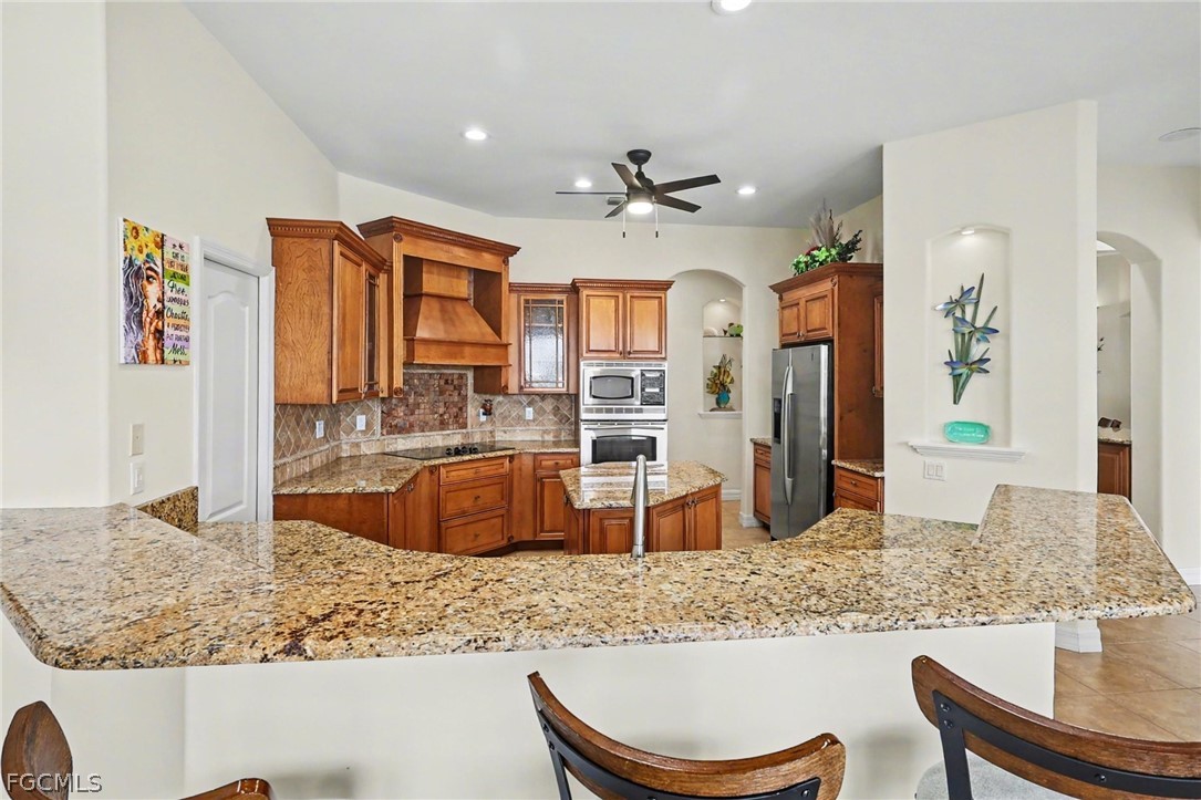 4113 Northwest 26th Street Cape Coral, FL 33993 - Photo 11 of 37 a large kitchen with granite countertop a sink a counter top space and stainless steel appliances