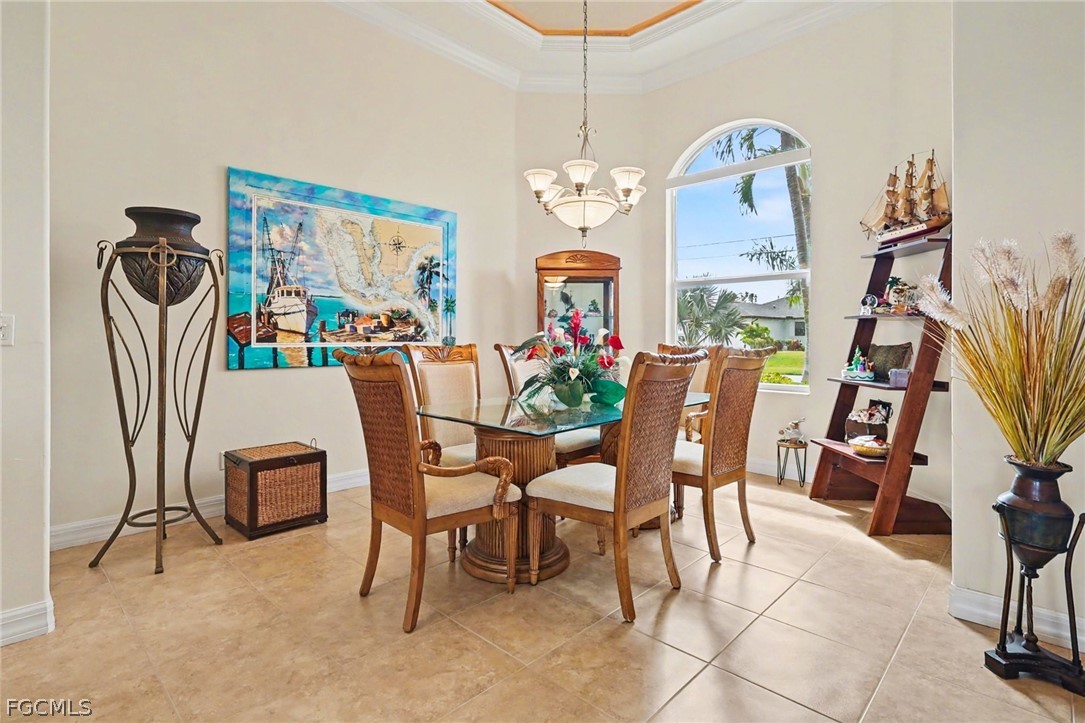 4113 Northwest 26th Street Cape Coral, FL 33993 - Photo 12 of 37 a dining room with furniture a rug a potted plant and a chandelier