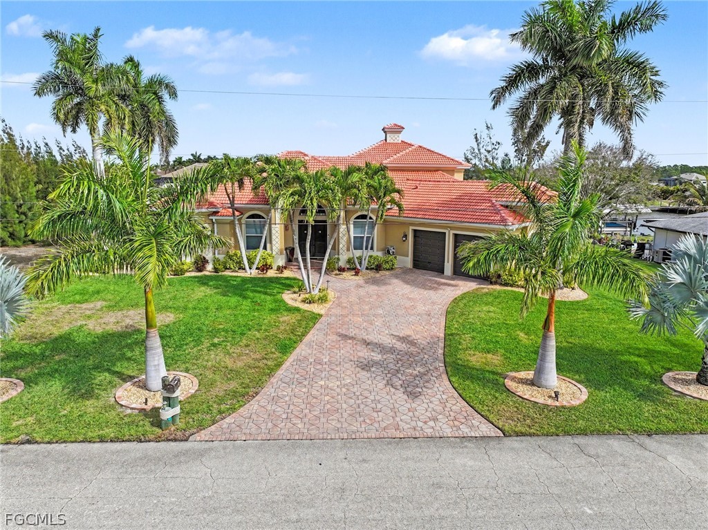 4113 Northwest 26th Street Cape Coral, FL 33993 - Photo 4 of 37 a front view of a house with a garden and palm trees