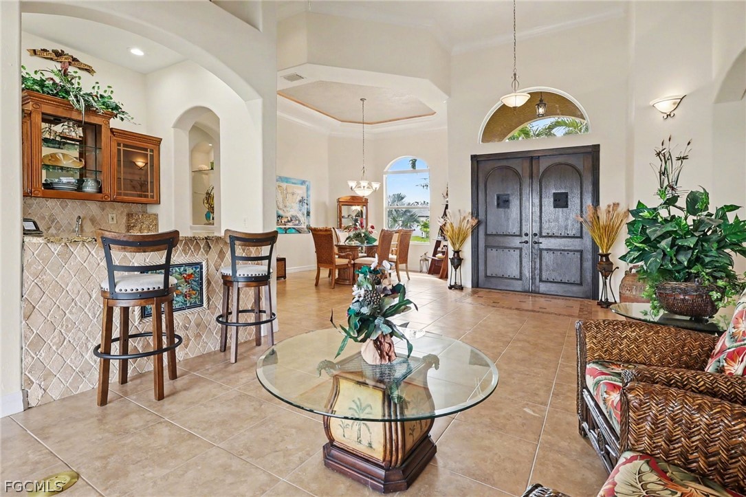 4113 Northwest 26th Street Cape Coral, FL 33993 - Photo 6 of 37 a living room with furniture a chandelier and a dining table