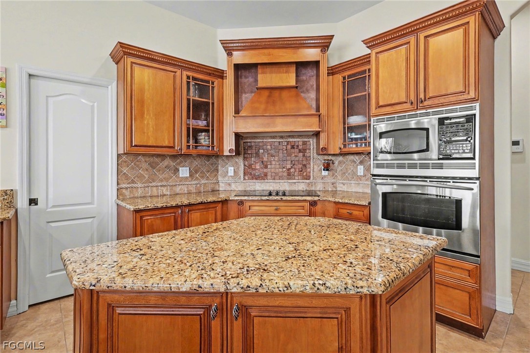 4113 Northwest 26th Street Cape Coral, FL 33993 - Photo 9 of 37 a kitchen with stainless steel appliances granite countertop wooden cabinets and a granite counter tops