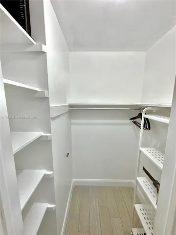 a view of walk in closet with empty racks
