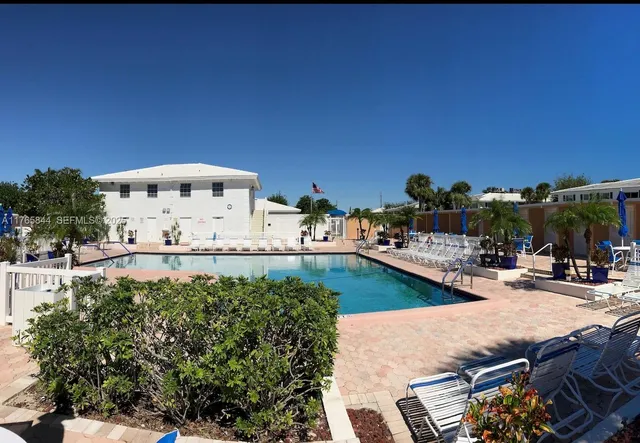 a view of a swimming pool with outdoor seating and a pathway