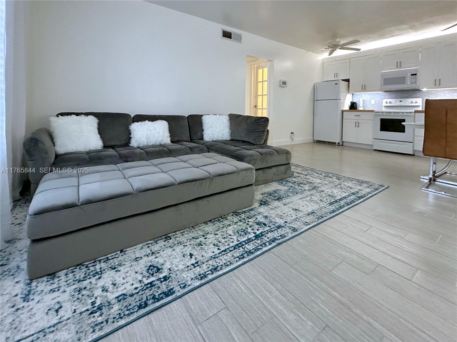 2201 Northeast 66th Street, Unit 1301 Fort Lauderdale, FL 33308 - Photo 2 of 23 a living room with furniture and a rug