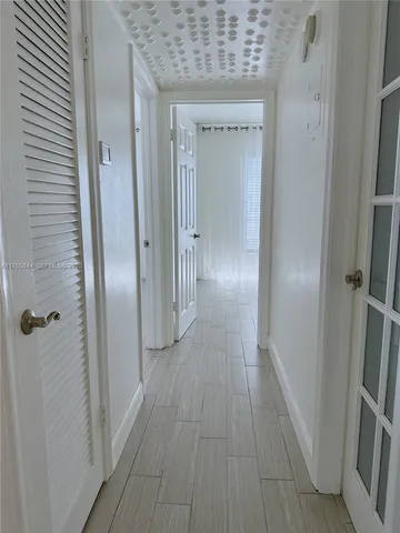 a view of a hallway with wooden floor
