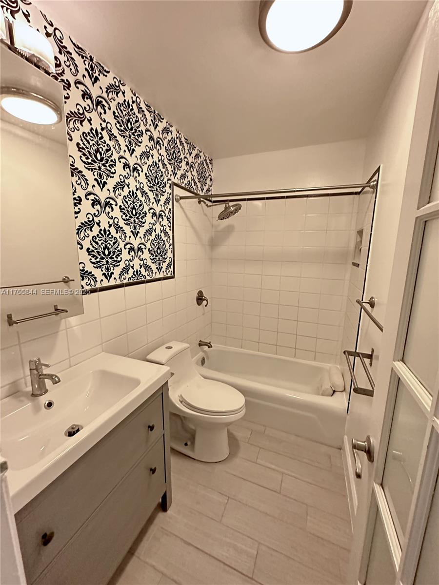 2201 Northeast 66th Street, Unit 1301 Fort Lauderdale, FL 33308 - Photo 7 of 23 a bathroom with a sink a toilet and shower