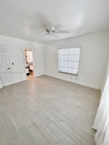 an empty room with windows and cabinet