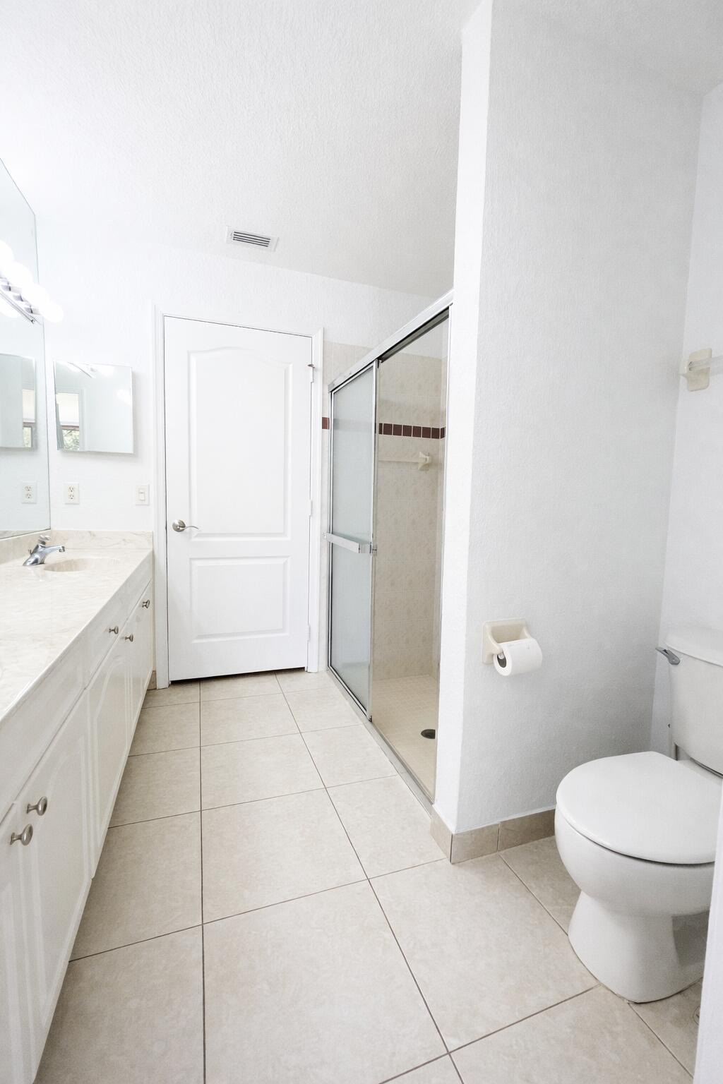13218 86th Road North West Palm Beach, FL 33412 - Photo 25 of 40 a bathroom with a granite countertop sink a toilet and a shower